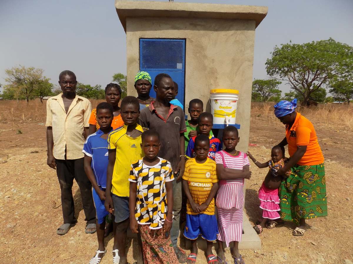 Familien stehen vor einem Toilettenhaus