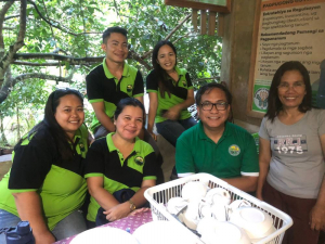 Das Foto zeigt vier philippinische Frauen und zwei Männer. Sie lächeln in die Kamera. Fünf von ihnen haben T-Shirts der Kooperative an.